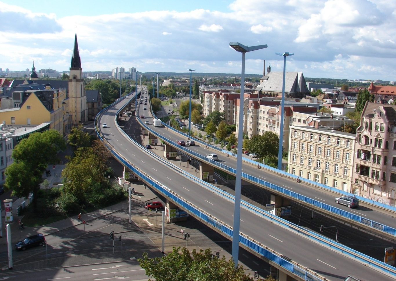 Detektiv Halle Saale Stadtansicht mit einer Autobahn und der Skyline im Hintergrund, bewölkter Himmel.